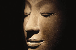 Description: [stone sculpture of Buddha head in meditation]
