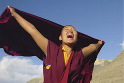 Description: [joyful young nun extends arms overhead as wrap blows in the wind]