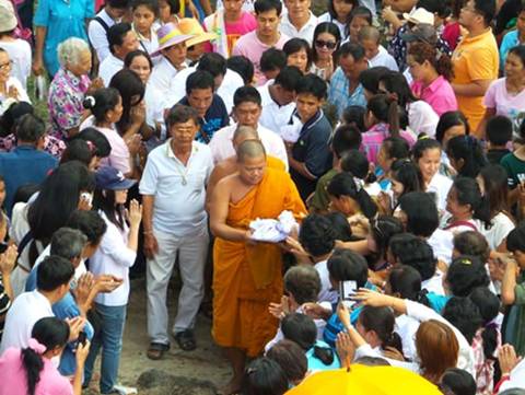 Description: Baideeka Kittisak Attakovito, abbot at Dokkrai Temple, collects precious items to put into the Buddha statue.