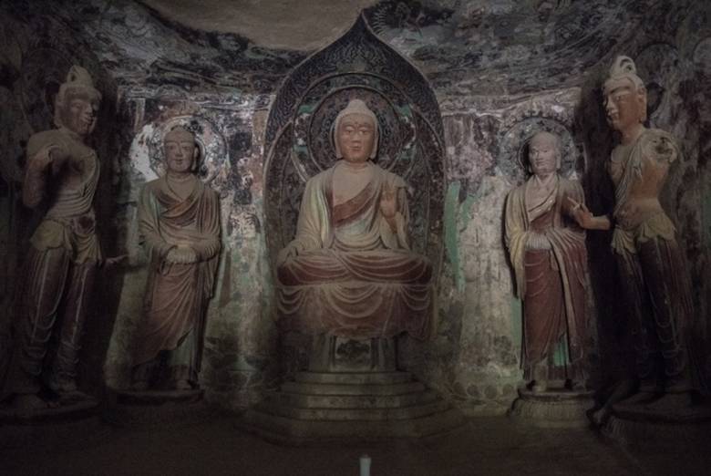 In a Mogao cave, a Buddha statue surrounded by disciples dating from the Tang dynasty (618907). Photo by Gilles Sabri. From washingtonpost.com