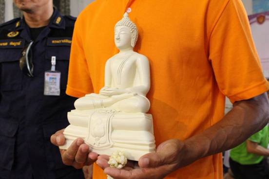 An inmate presents his masterpiece during a recent press conference focusing on the Corrections Departments project encouraging prisoners to sculpt Buddha statues.