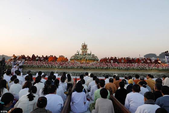 Description: People watching on as Myanmar and Thai Buddhist monks take part in an alms offering-ceremony. Around 30,000 Buddhist monks from the two neighbouring countries attended the event today