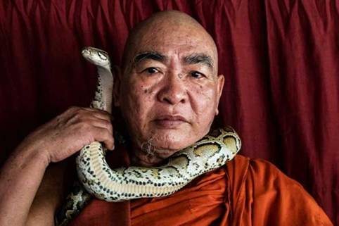 Buddhist monk Wilatha poses with a rescued Burmese python at his monastery that has turned into a snake sanctuary on the outskirts of Yangon, Myanmar.