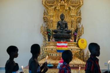 A statue of Mirembe, which means peace in Luganda, watches over followers. The statue was made from metal offered by Thai people. 