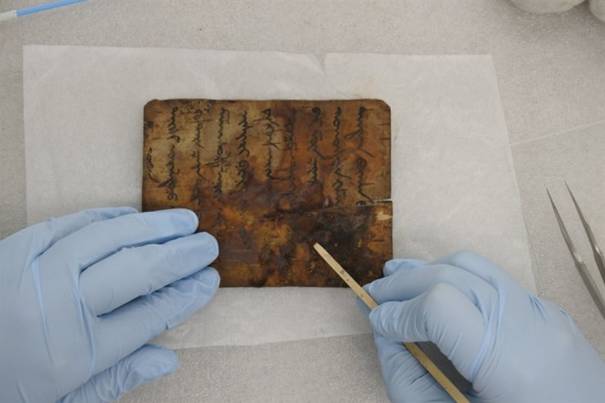 A conservation scientist cleans a Buddhist scripture written on bark from Mongolia at the Cultural Heritage Conservation Science Center. / Courtesy of National Research Institute of Cultural Heritage