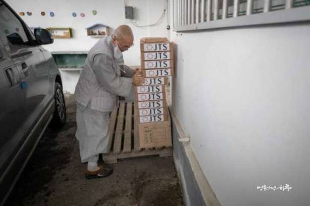 Ven. Pomnyun Sunim prepares boxes of rice cakes. Image courtesy of Jungto Society