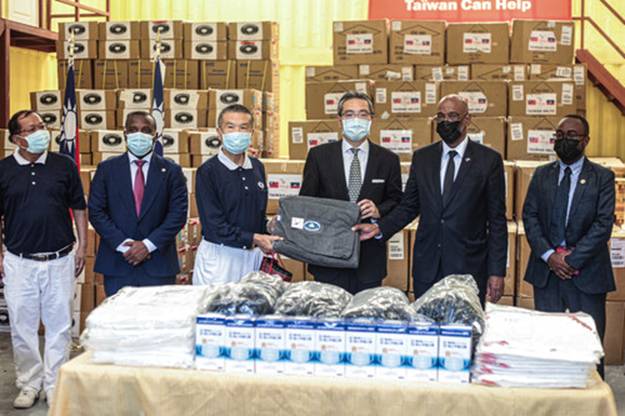 Tzu Chi volunteers Johnson Chang (far left) and James Chen (center left) unite with Ambassador to Haiti from Taiwan Richard Ku (center), and his Excellency, Prime Minister of the Republic of Haiti, Ariel Henry (second from right) at a humanitarian donation ceremony in Port-au-Prince, Haiti. Photo/Tzu Chi Haiti Disaster Response Team